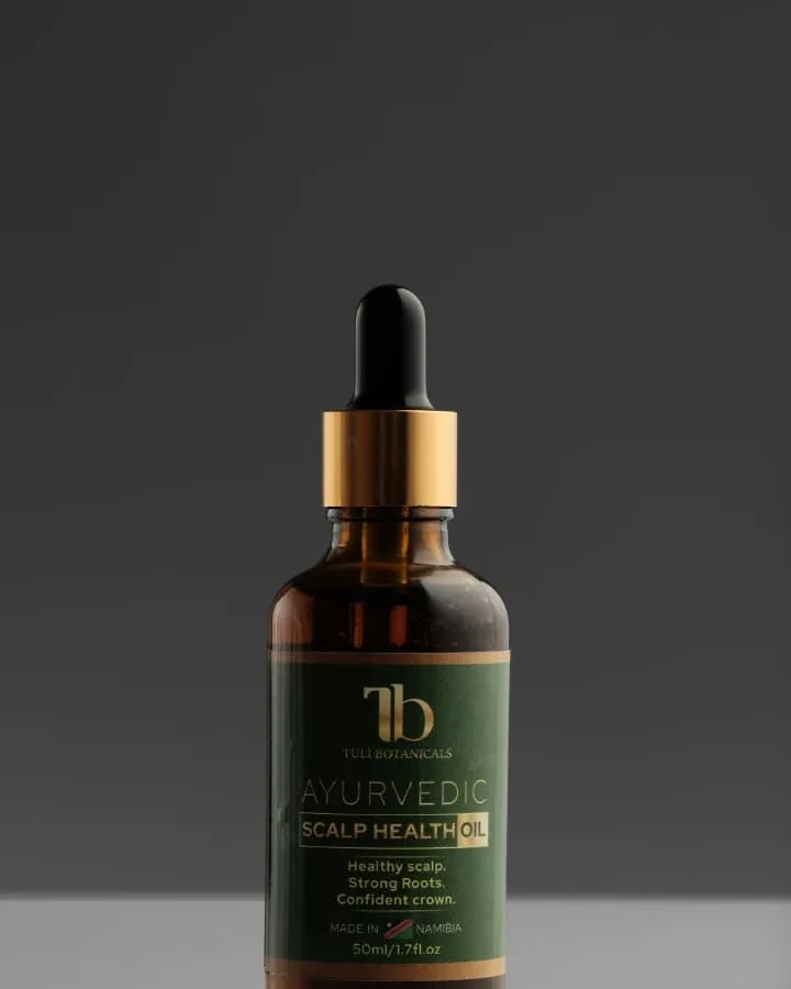 Tuli Botanicals oil bottle photographed against a warm grey studio background.
