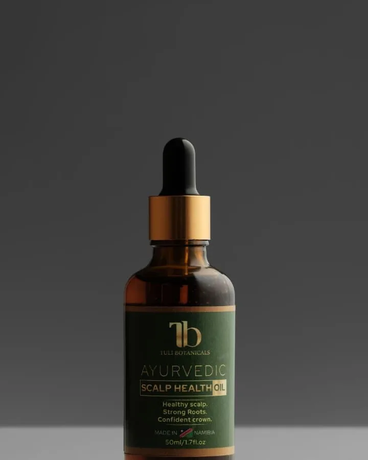 Close view of the Tuli Botanicals oil bottle label against a grey studio background.